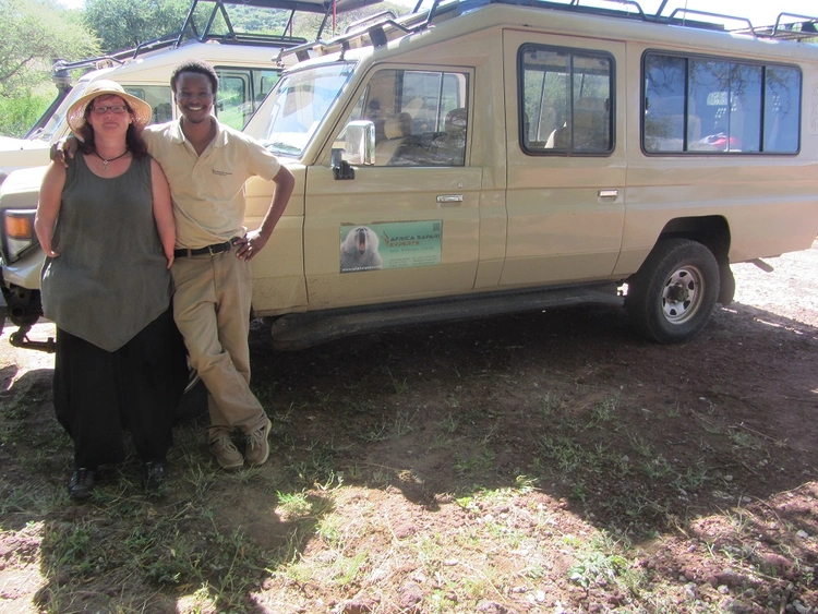 Guide und Touristin vor Safariauto